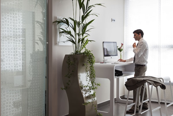 A modern office with a desk, computer, and a potted plant. - Novotel Suites Malaga Centro (Málaga)