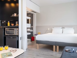 Suite superior, varias camas | Ropa de cama de alta calidad, edredón y minibar