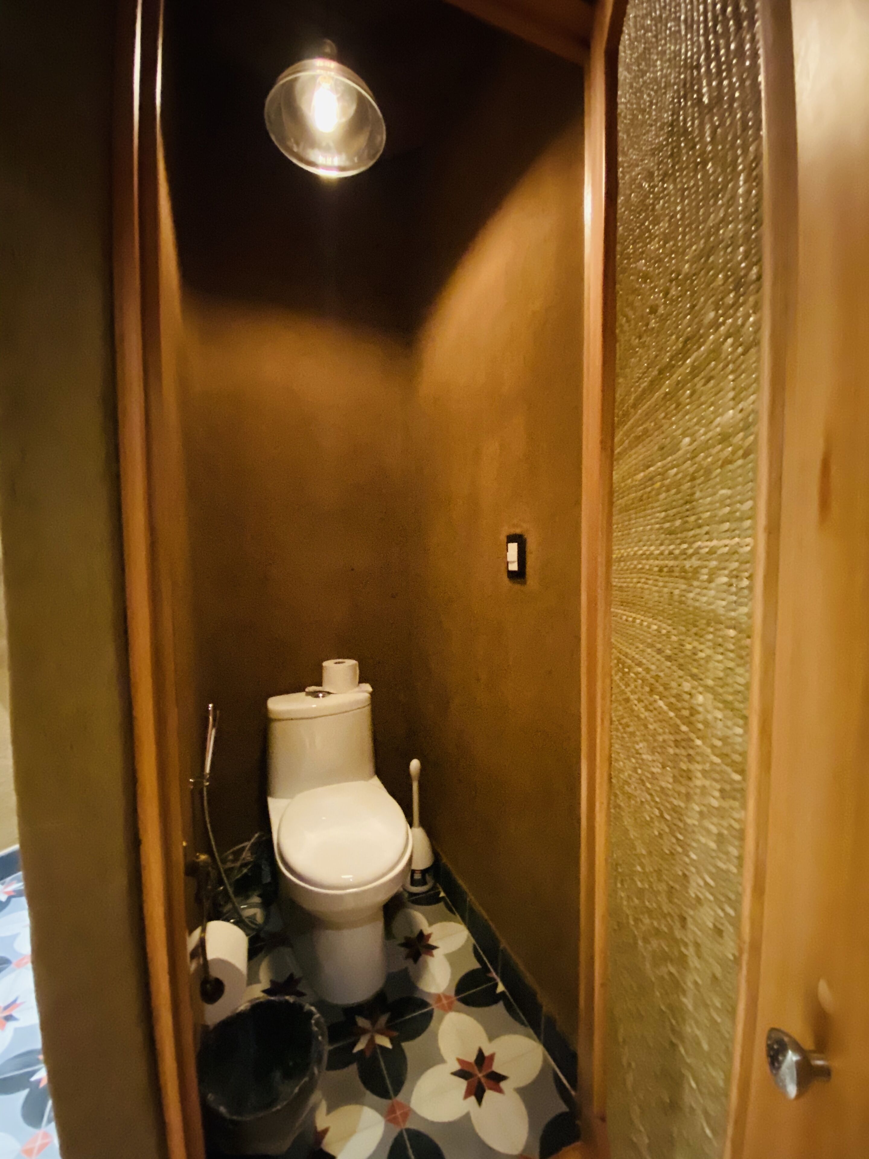 Un baño pequeño y estrecho con inodoro, bidé y cabezal de ducha.