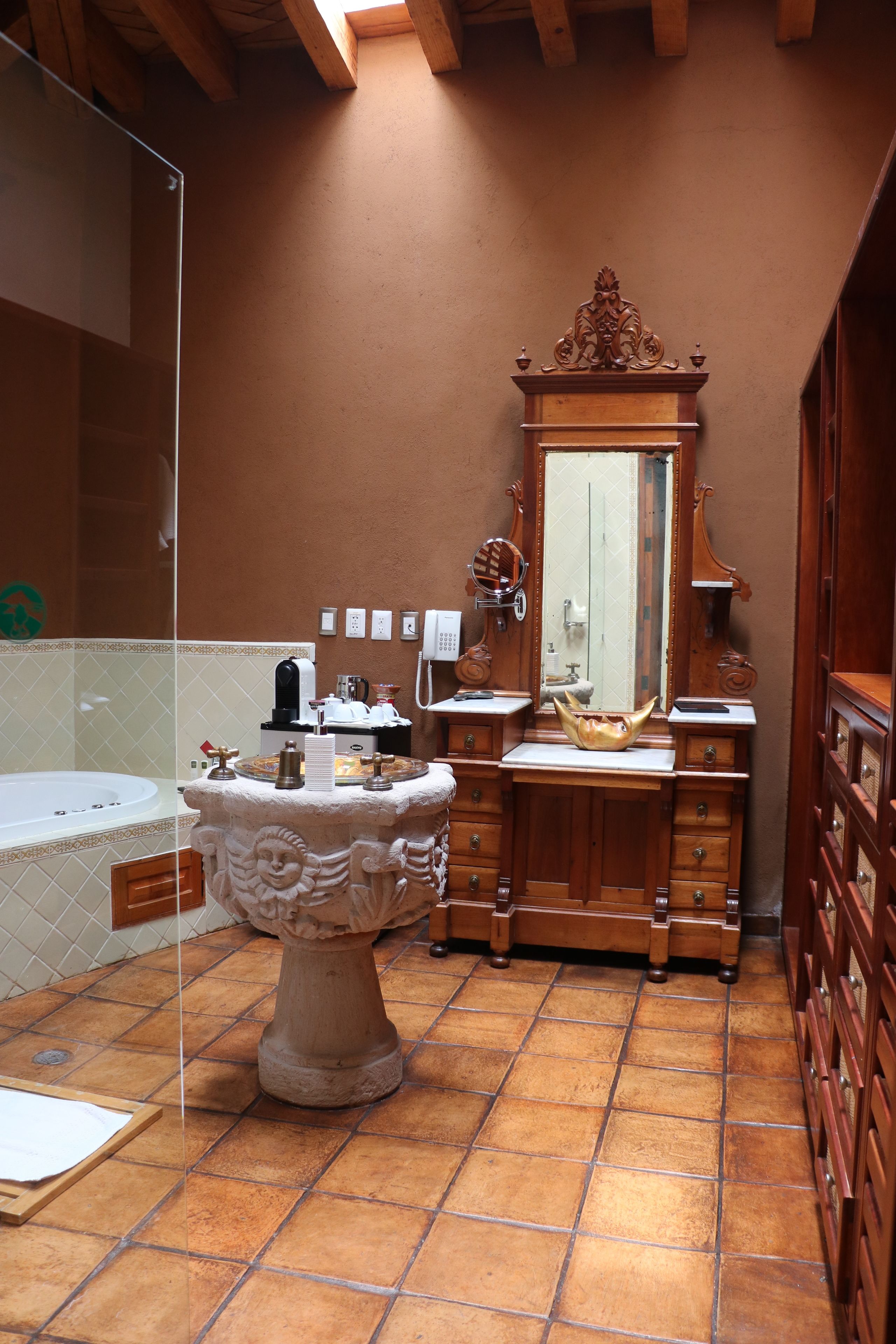 A bathroom with a freestanding bathtub, wooden vanity, and a large mirror.