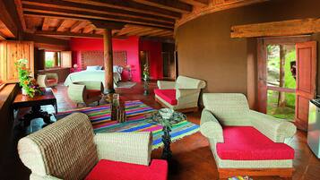Una habitación amplia con una cama grande, muebles de mimbre y una alfombra colorida.