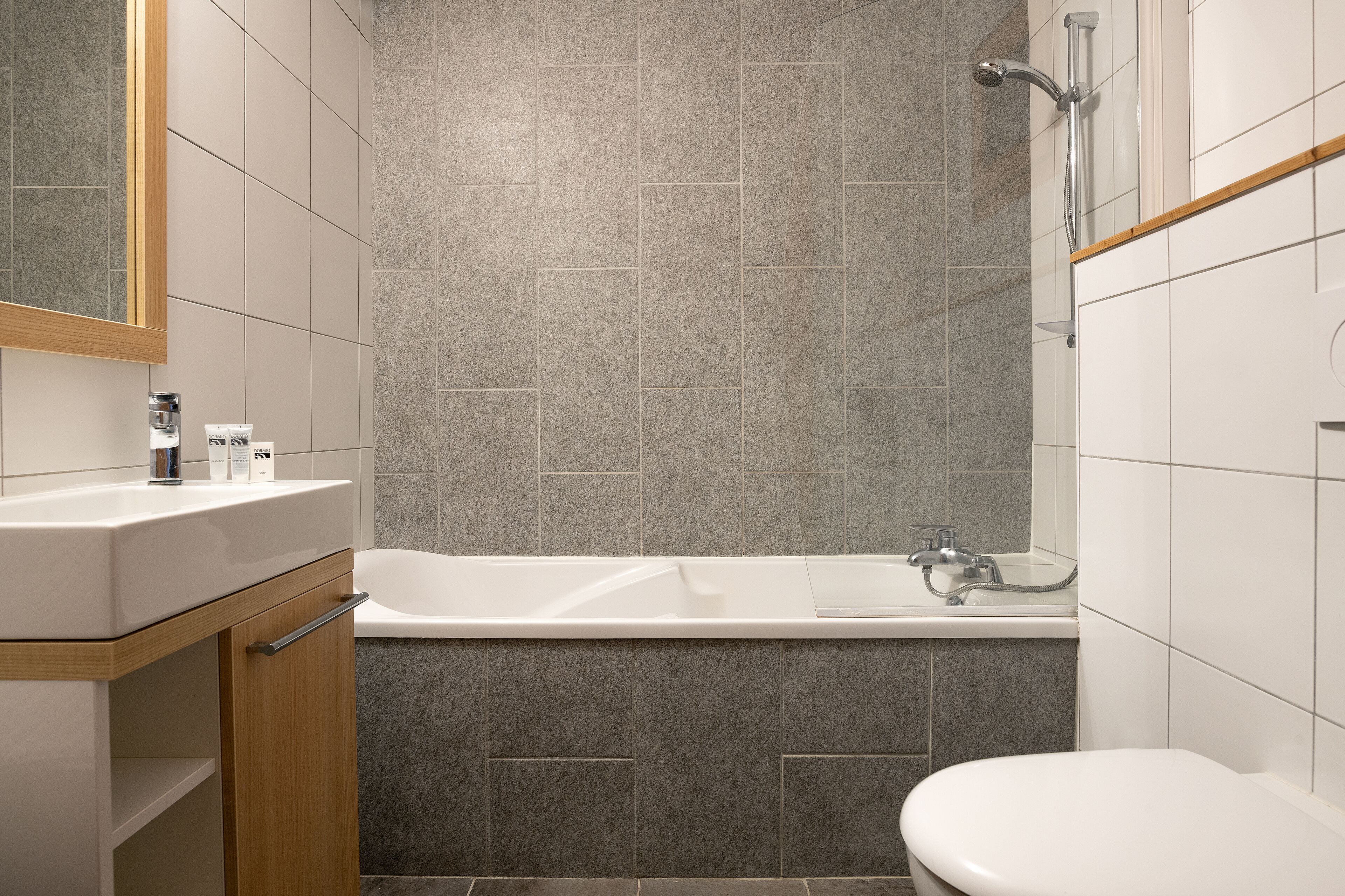 A modern bathroom with a bathtub, a toilet, and a sink.