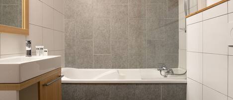 Un baño moderno con bañera, inodoro y lavamanos.
