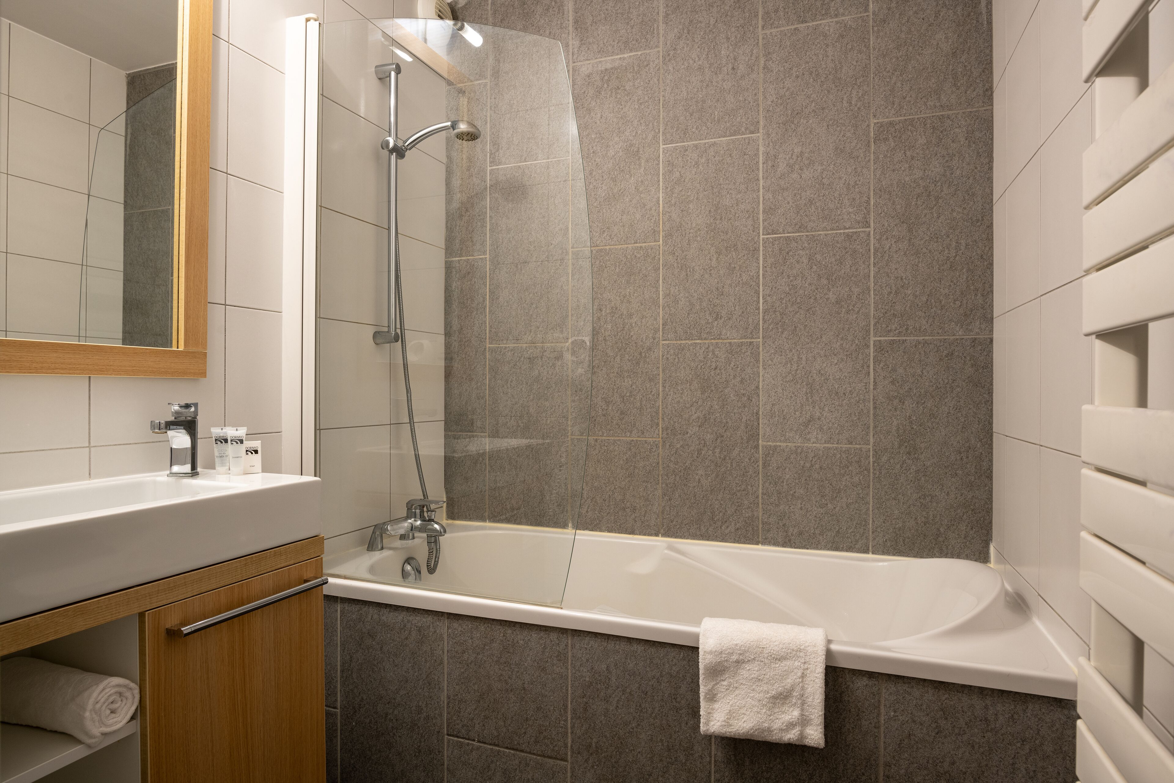 Une salle de bain moderne avec une baignoire, une douche et un meuble en bois.