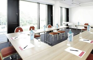 A conference room with a long table, chairs, and water dispensers. - Hotel Berlin Alexanderplatz by Leonardo Hotels (Berlin)