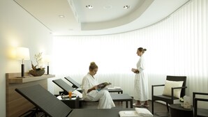 Ein Wellnessraum mit Liegesesseln, einem Stehsessel und einer Massageliege.