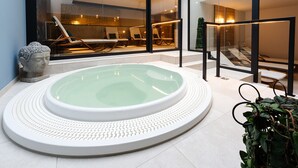 A spa area with a hot tub, lounge chairs, and a Buddha statue. - Relax Hotel Restaurant Pip Margraff (Sankt-Vith)