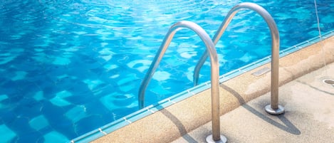 Una piscina al aire libre de temporada, sillones reclinables de piscina