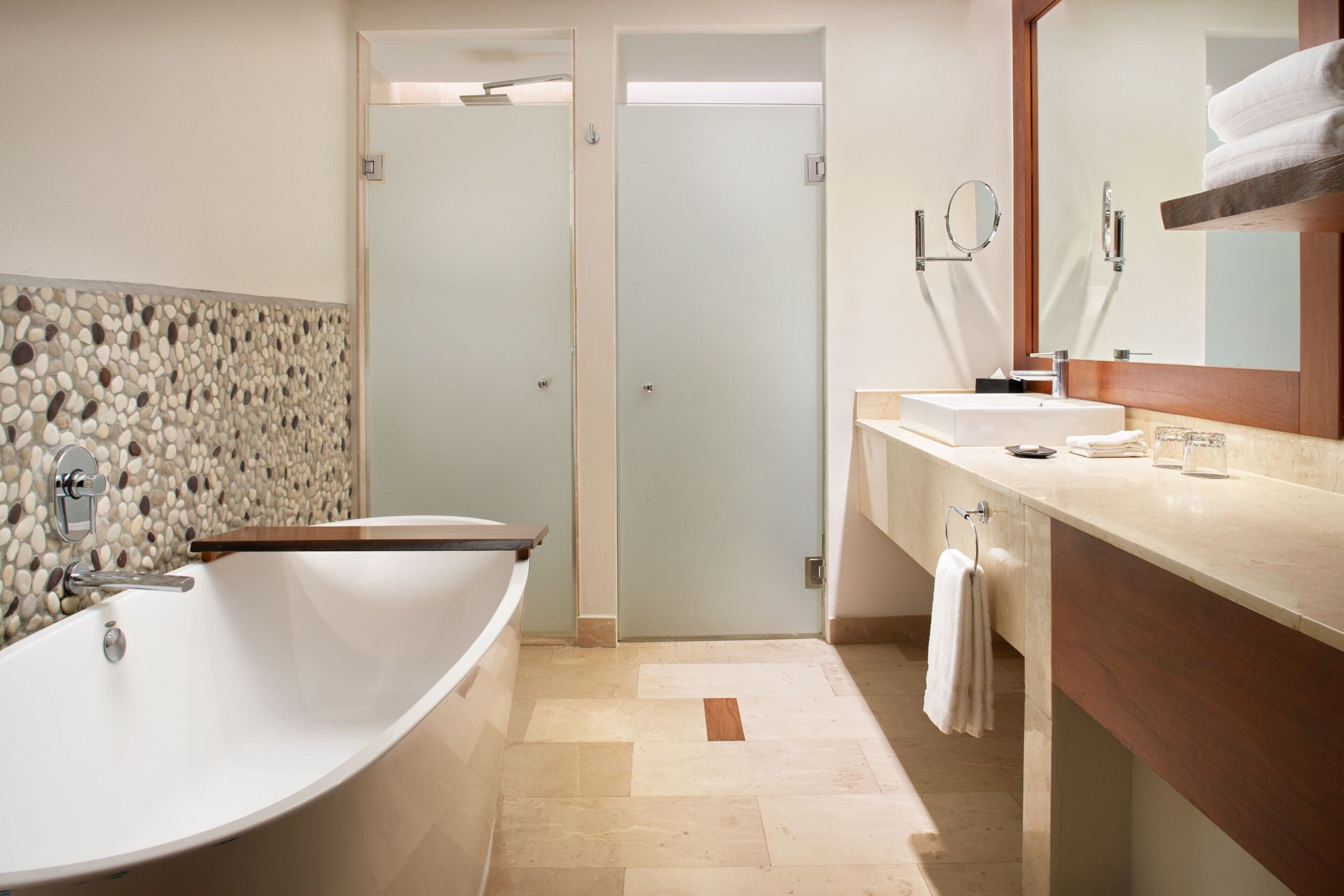 Un baño moderno con una bañera independiente, un tocador con espejo y una zona de ducha.