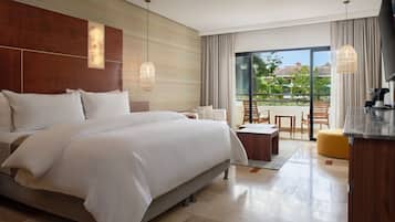 Una habitación de hotel moderna con una cama grande, un balcón con asientos y vistas al exterior.