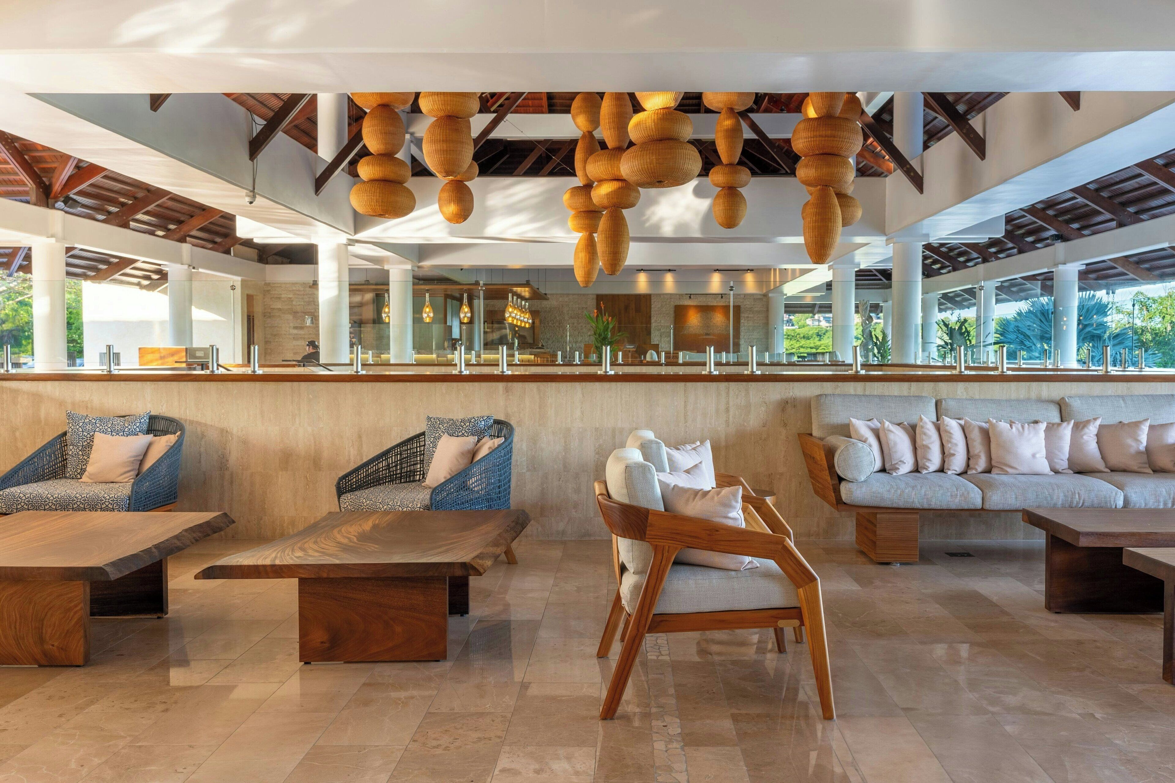 A spacious lobby with a high ceiling, large windows, and a variety of seating options including sofas and chairs.