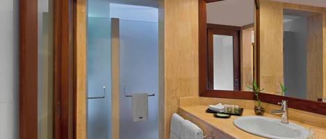 A modern bathroom with a large mirror, a sink, and a shower area.