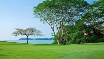 Enjoy a round of golf on our well-maintained course surrounded by lush trees and a serene body of water.
