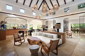 A spacious living area with a sofa, chairs, a coffee table, and a bar area with a counter and bar stools.