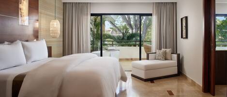 Una habitación de hotel moderna con una cama grande, un sofá, un ventilador de techo y vistas al exterior.