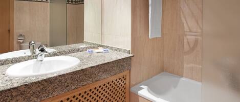 A bathroom with two sinks, a shower, and a bathtub.