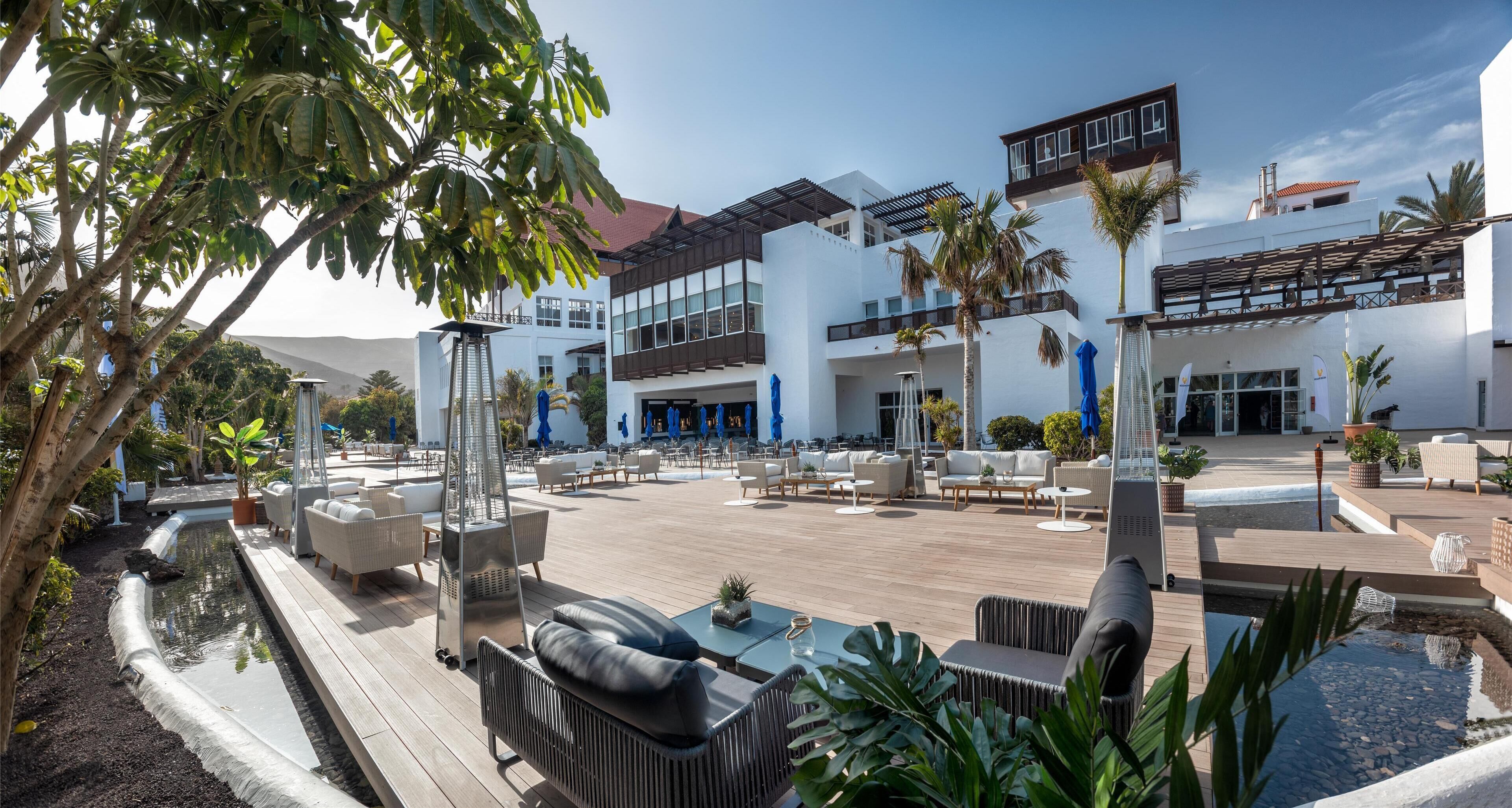 Un hôtel moderne doté d’une piscine, d’un espace extérieur aménagé et d’un bâtiment à deux étages.