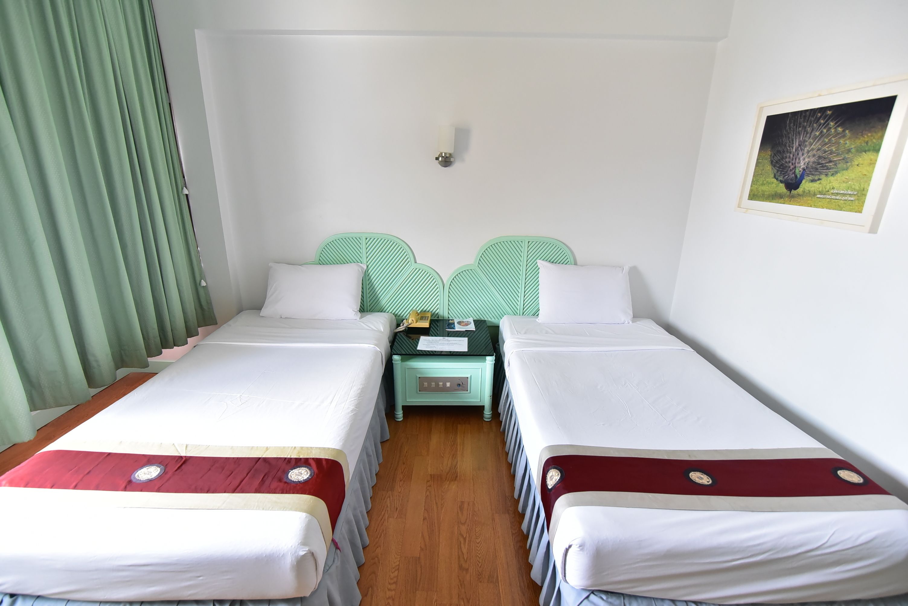 Ein Doppelzimmer mit zwei Betten, einem Nachttisch und einer Wandleuchte.