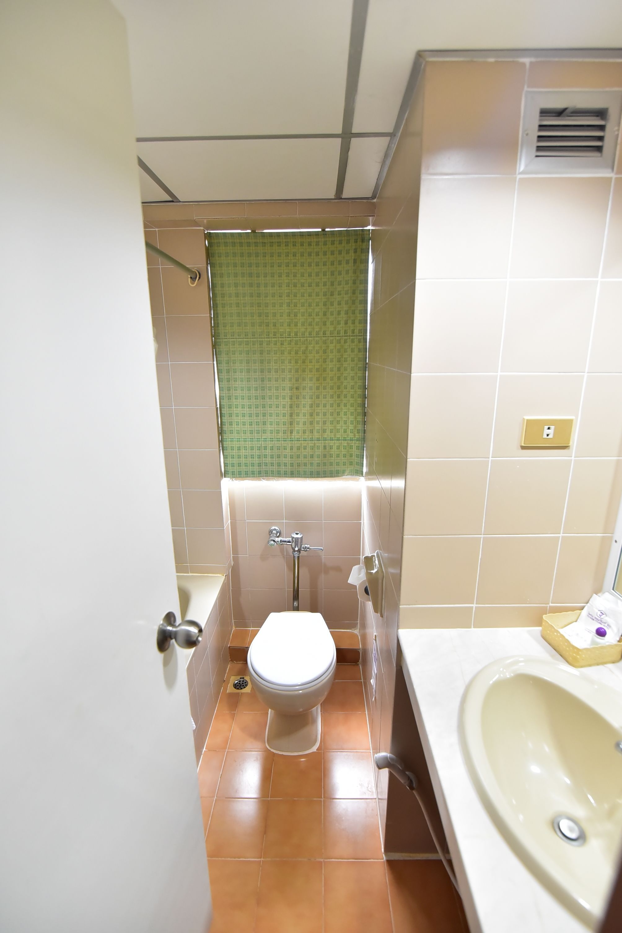 Un baño con inodoro, lavamanos y zona de ducha.