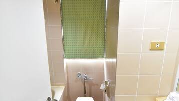 Un baño con inodoro, lavamanos y zona de ducha.