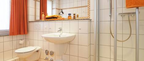 A bathroom with a toilet, sink, and shower.