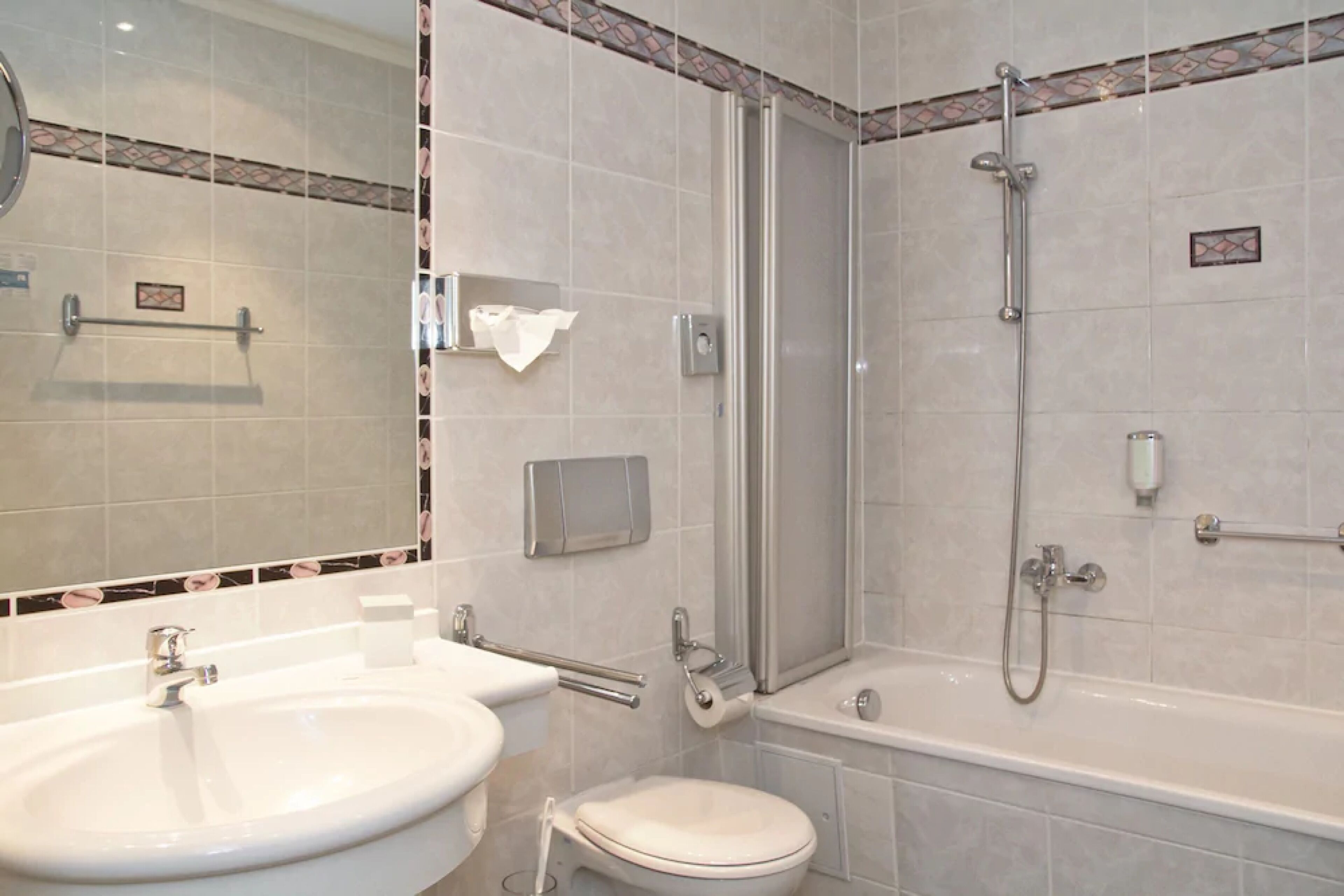 Un baño con lavamanos, inodoro y ducha.