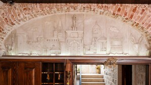 Un muro de ladrillo con un relieve que representa diferentes elementos arquitectónicos.