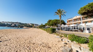 Una playa con un hotel llamado Sant Pol, con mesas al aire libre y vistas al mar.