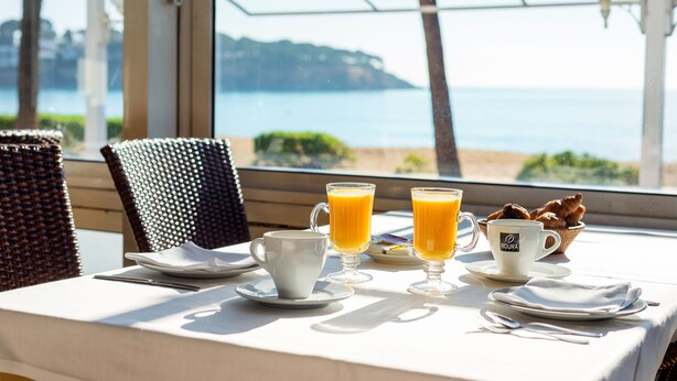 Una mesa dispuesta para el desayuno con vista al mar.