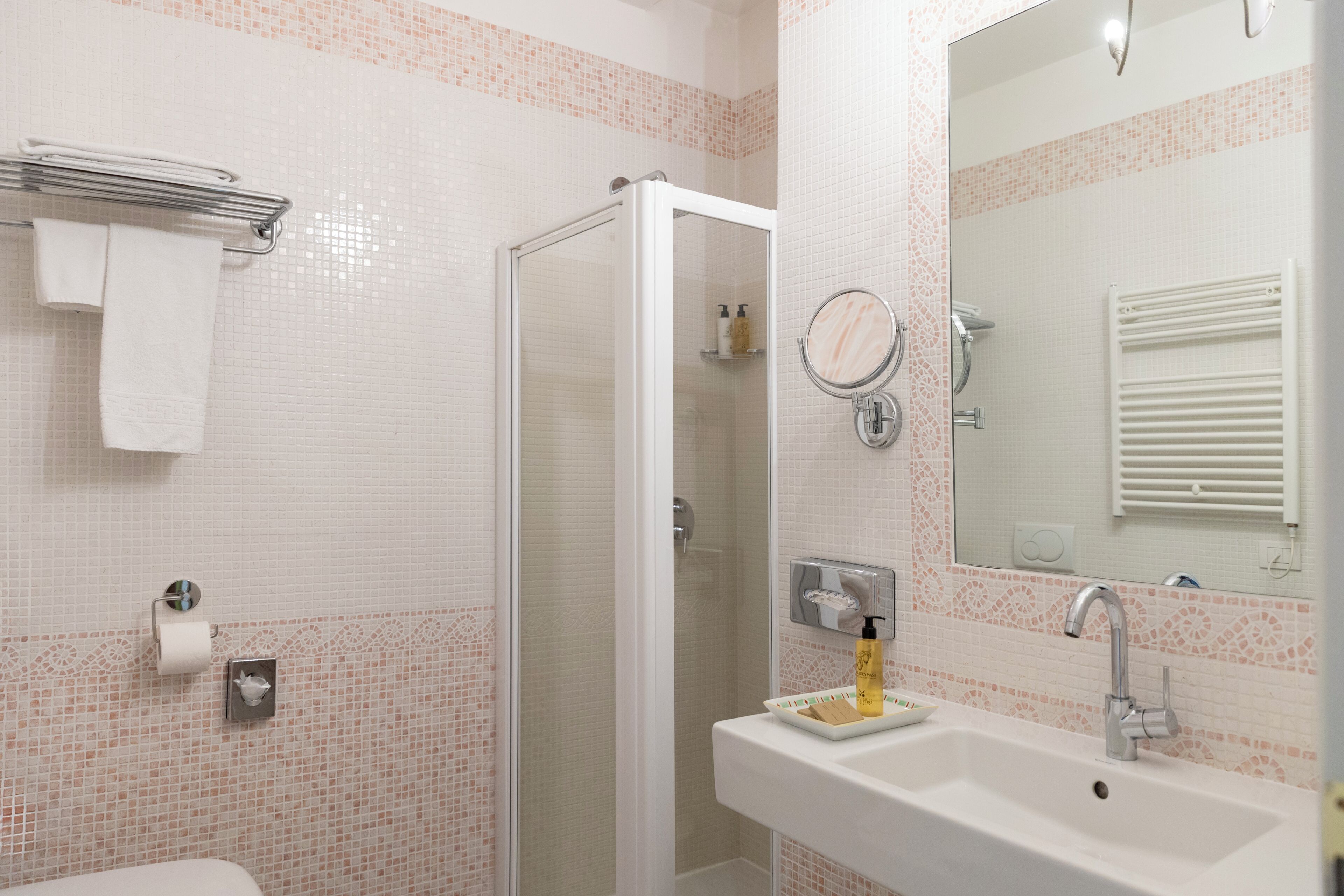 Un bagno con doccia, lavandino e specchio.