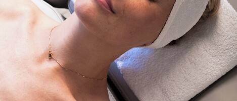 Una persona acostada en una cama con una diadema blanca y una toalla blanca.