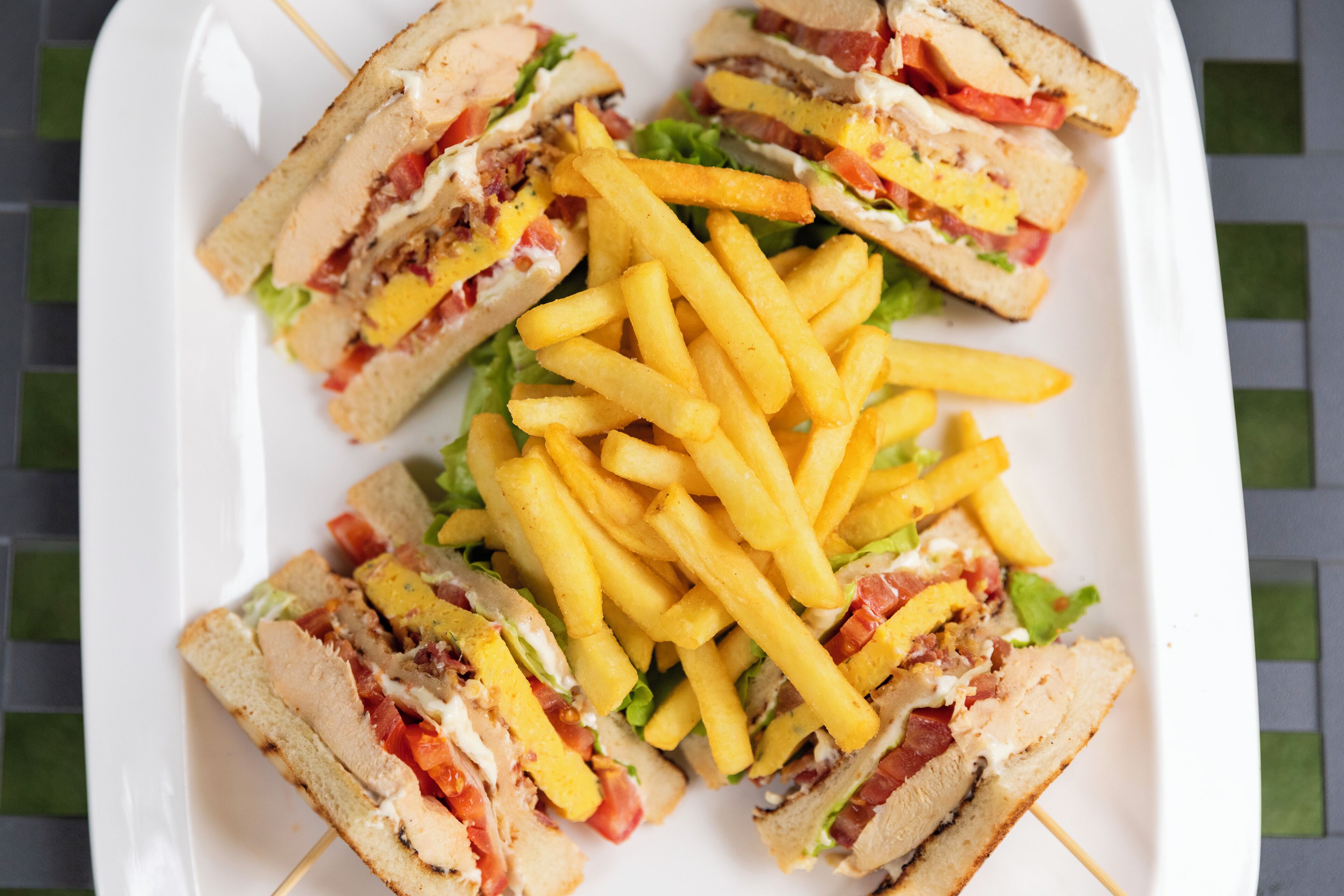 A plate of sandwiches and french fries.