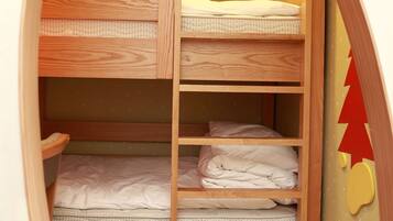 Una cama litera con estructura de madera y una pared amarilla decorada con estrellas.