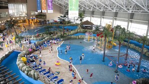 An indoor water park with multiple pools, slides, and water play areas.