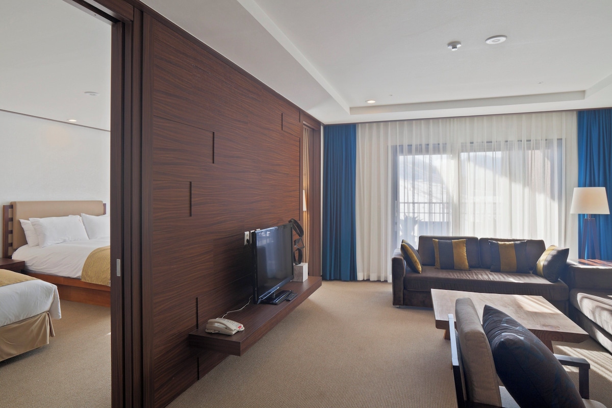 Een hotelkamer met een bed, televisie, bank en bureau.