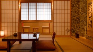 Et traditionelt japansk rum med tatamimåtter, et lavt bord og shoji-skærme.