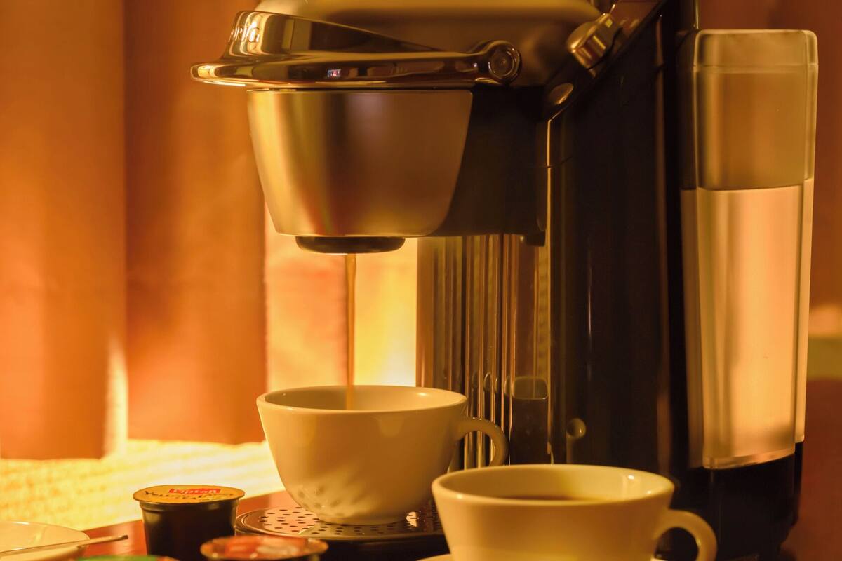 Een koffieapparaat schenkt koffie in een kopje.