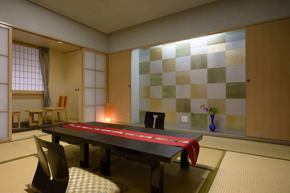 Een traditionele Japanse kamer met tatami vloerbedekking, een lage tafel en shoji schermen.