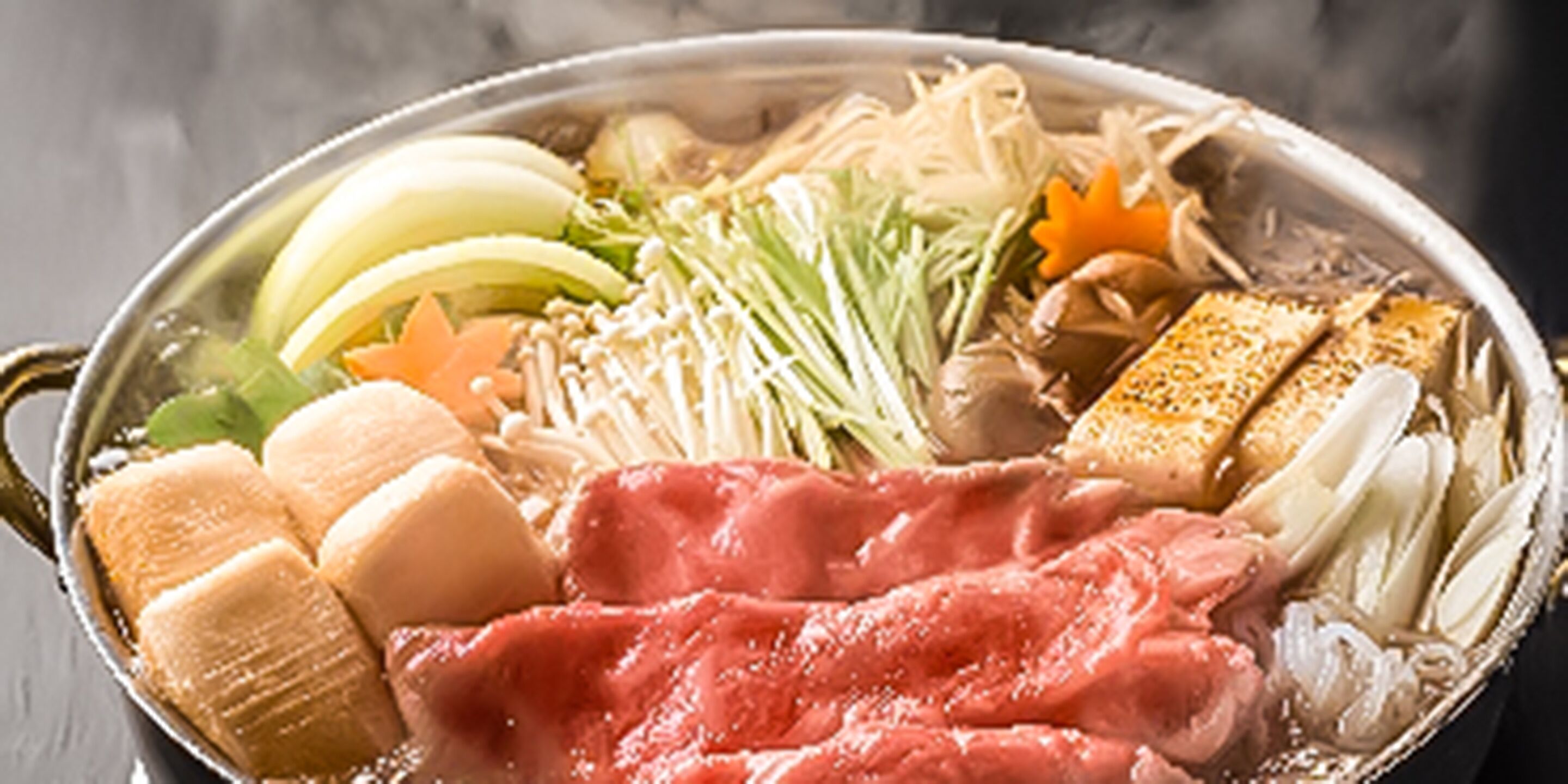 A hot pot with various ingredients like meat, vegetables, and tofu.