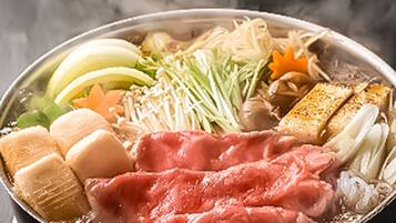A hot pot with various ingredients like meat, vegetables, and tofu.