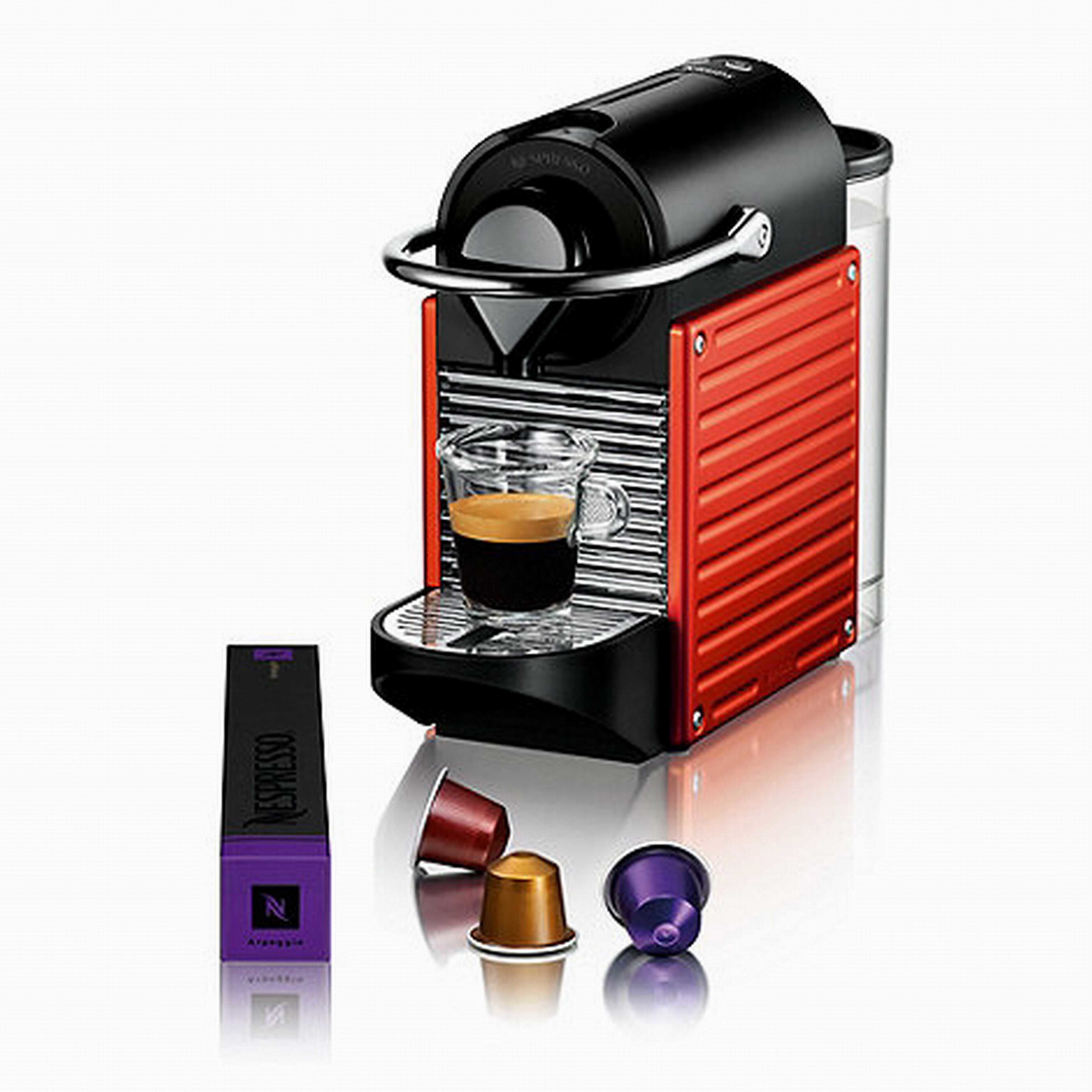 Eine Nespresso-Kaffeemaschine mit rotem und schwarzem Design, eine Glaskaraffe und zwei Kapseln.