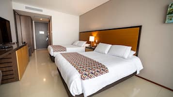 Habitación de hotel con una cama grande, un escritorio y un televisor.