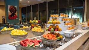 Un buffet con diversi tipi di frutta e una grande finestra sullo sfondo.