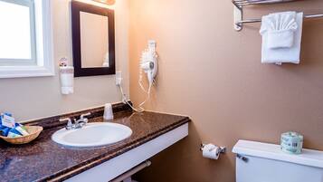 A bathroom with a sink, mirror, towel rack, and toilet.