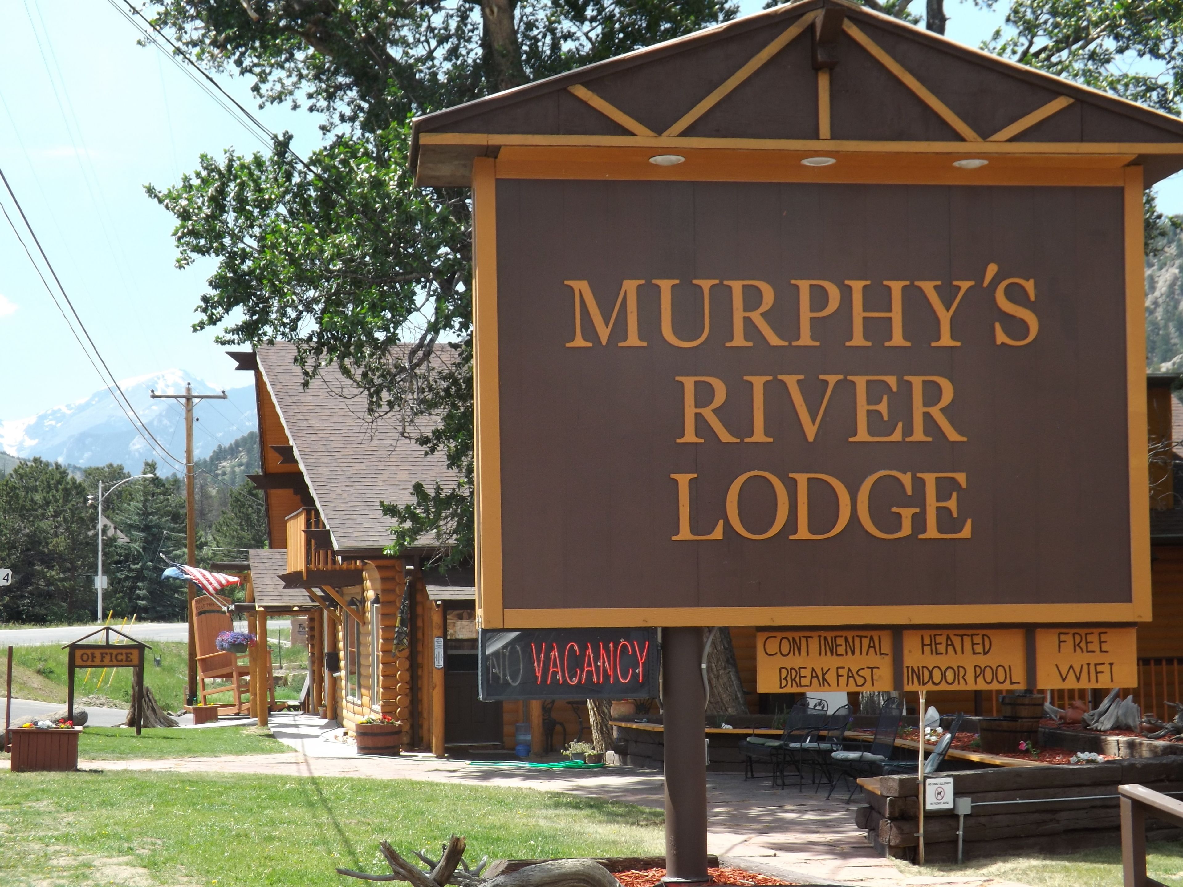 Een bord voor Murphy's River Lodge met hieronder een lijst van voorzieningen, waaronder een bord met vrije kamers.