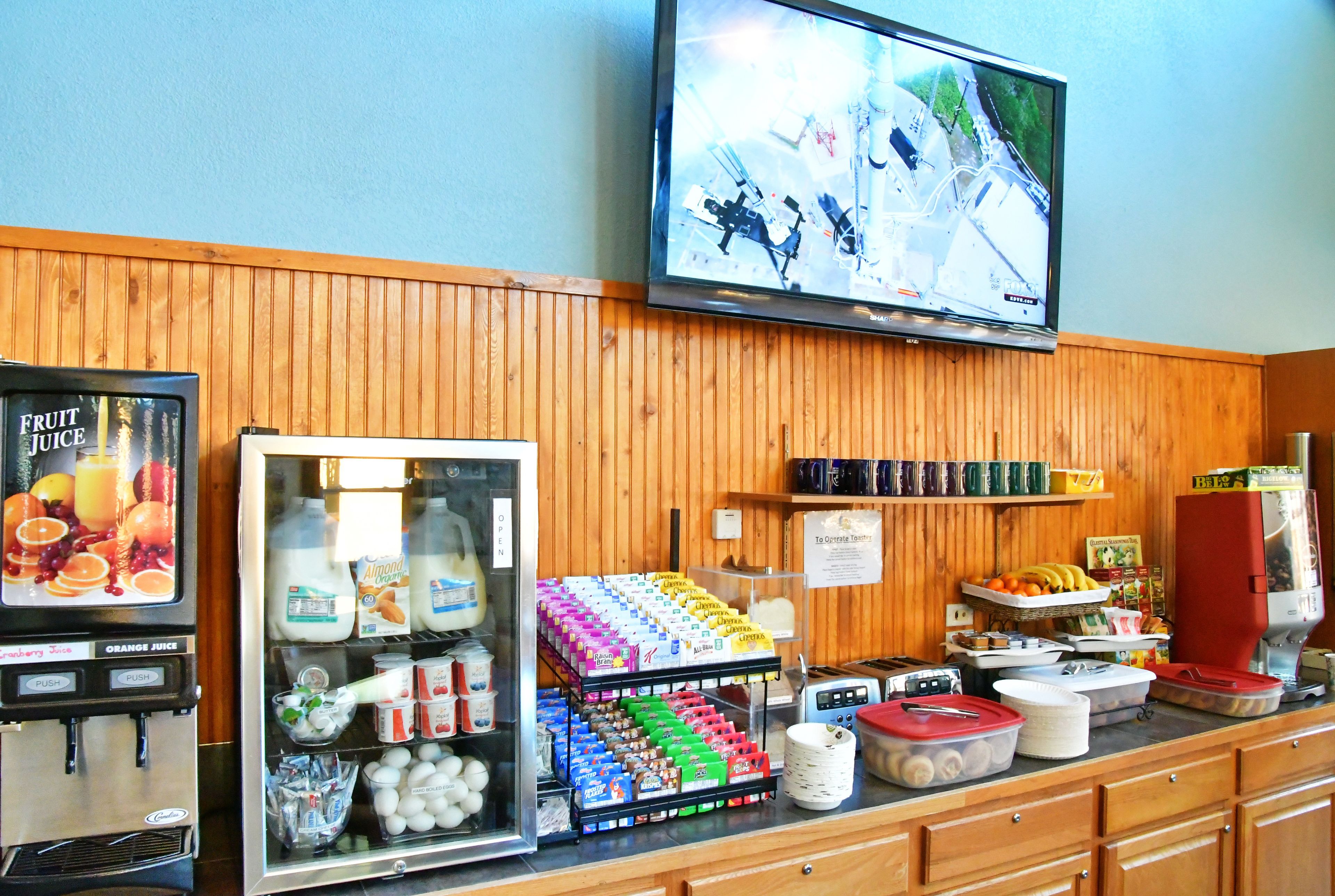Un angolo colazione con TV, distributori automatici e una selezione di prodotti alimentari.