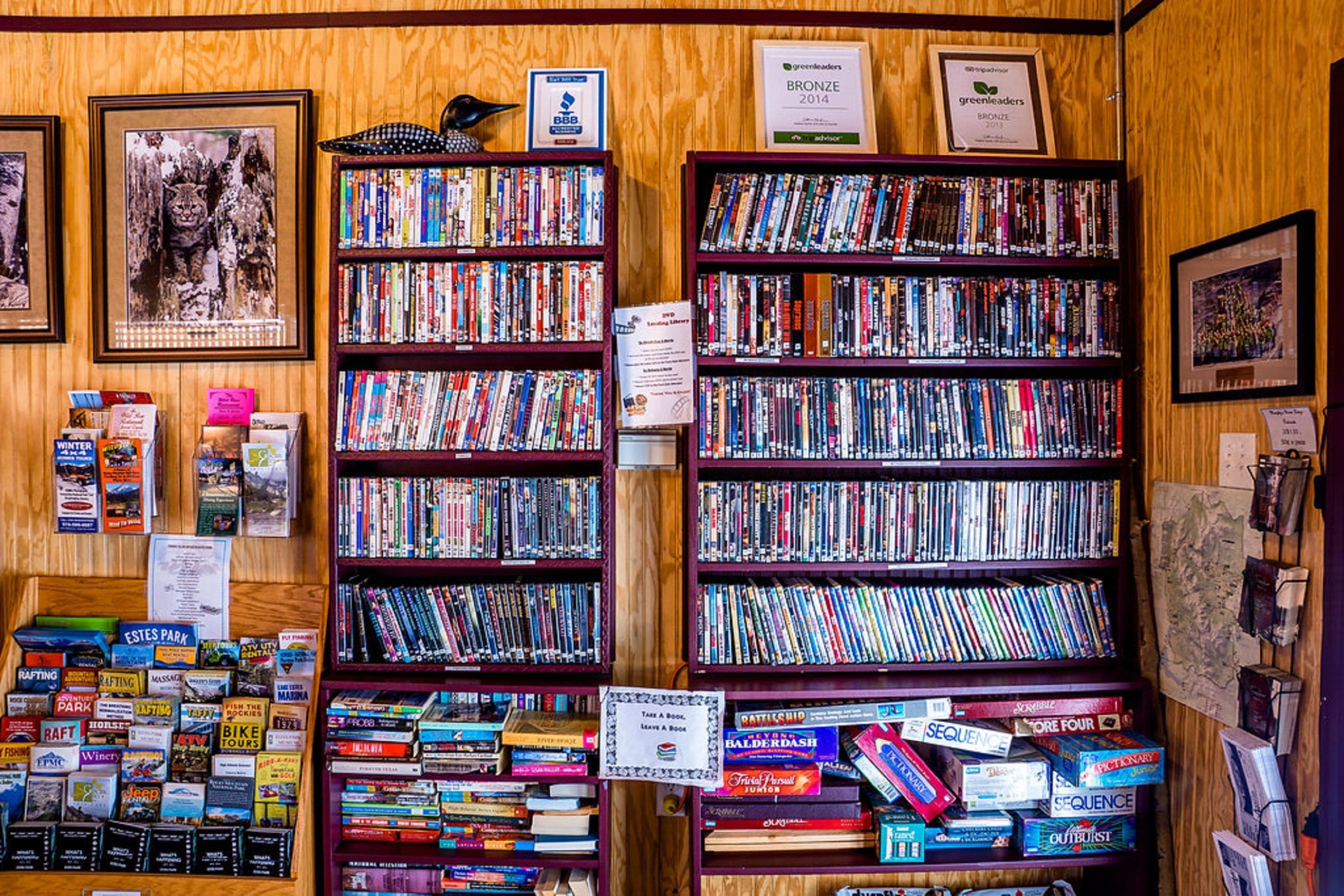 A bookstore with multiple shelves of books and a few framed pictures on the wall.