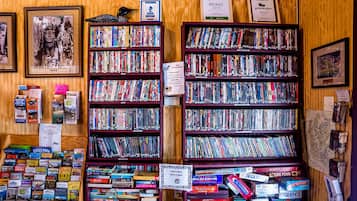 A bookstore with multiple shelves of books and a few framed pictures on the wall.