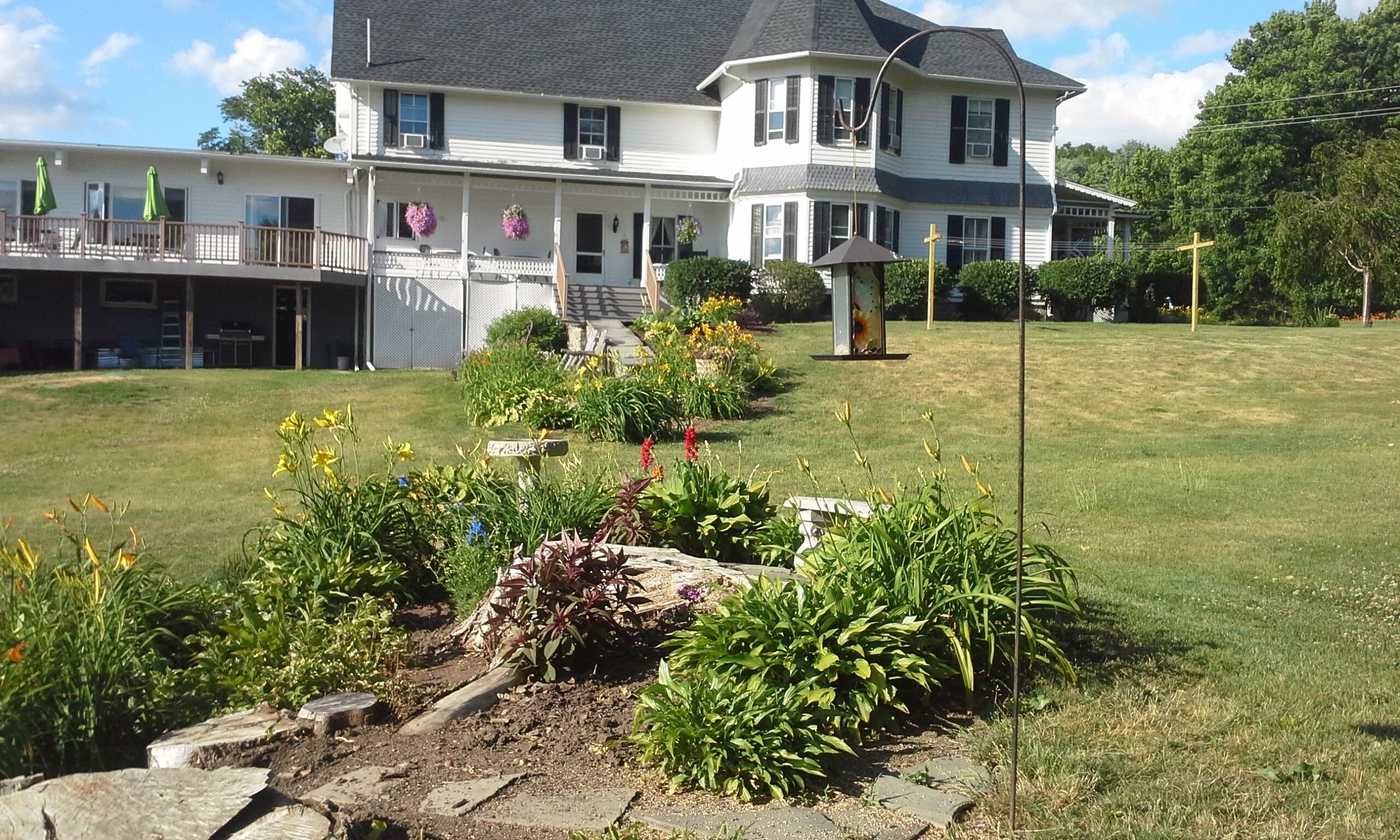 A large, two-story house with a well-maintained lawn and garden.