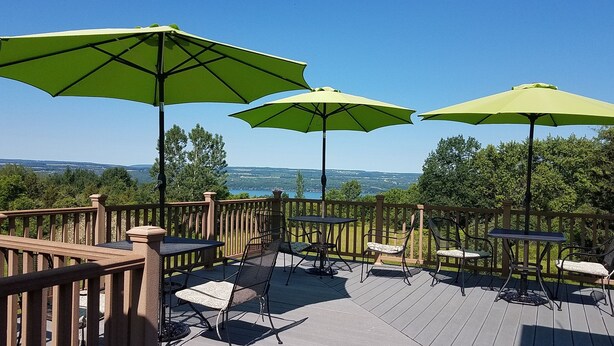 Une terrasse dotée de mobilier d’extérieur et de parasols, offrant une vue sur un paysage pittoresque.